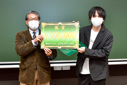 20201204ベンチャービジネスコンテスト-賞金を受け取り、笑顔の西岡さん(右)