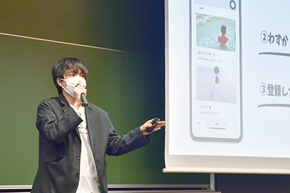 20201204ベンチャービジネスコンテスト--制作した「宿ふぁん」の画面を表示しながら熱くプランを説明する西岡さん