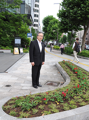 02000608神田10号館前に花壇‗10号館前の花壇を見守る佐々木学長