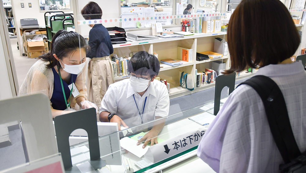 20220809司書インターンシップ_-カウンターで専大生への貸し出しを行う高校生