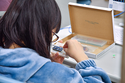 20221220情報科学研究所公開講座_-学生のサポートを受けながら作業に取り組む子どもたち