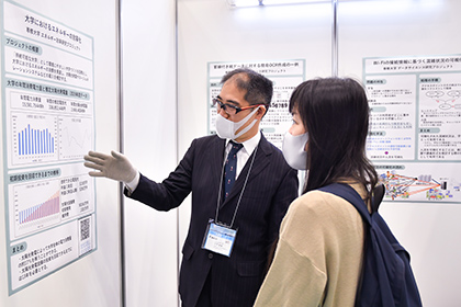 20221117～18川崎国際環境技術展_来場者に学生の研究の成果を説明する河野敏鑑准教授