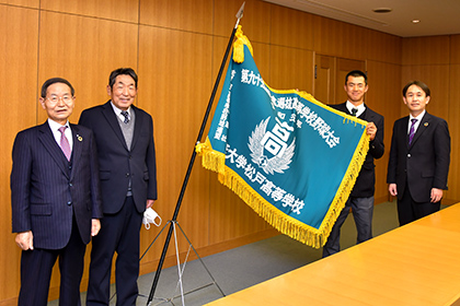 20230224センバツ出場の専大松戸高野球部関係者が専大を訪問_選抜旗を手にする大森主将と専大松戸高校関係者(左から富山理事長、持丸監督、五味校長)